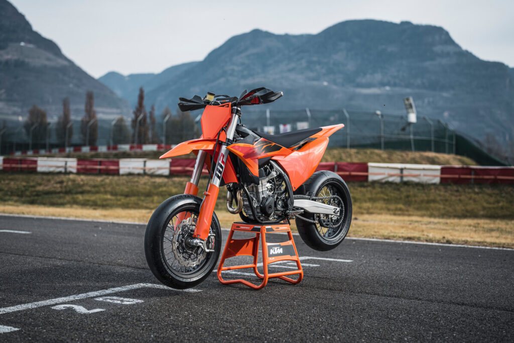 Orange 2027 KTM 450SMR on a stand at a race track. 