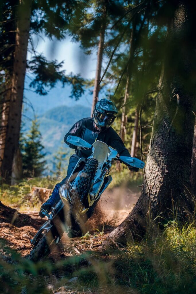 HUSKY’S 2027 TE300 being ridden through a forested track.